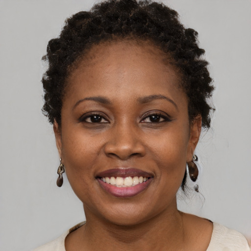 Joyful black young-adult female with short  brown hair and brown eyes