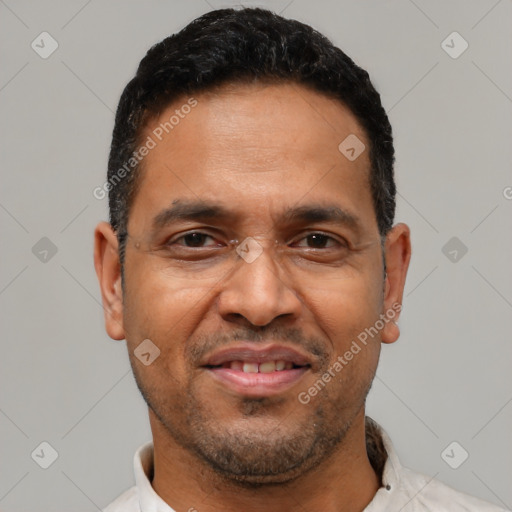 Joyful latino adult male with short  black hair and brown eyes