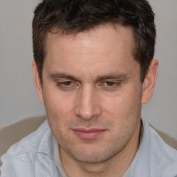 Joyful white adult male with short  brown hair and brown eyes