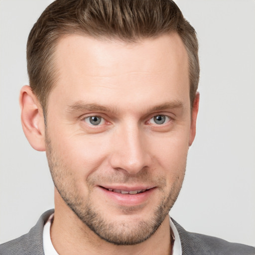 Joyful white young-adult male with short  brown hair and grey eyes