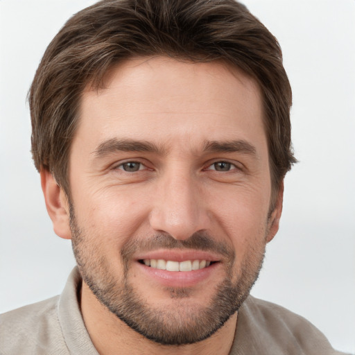 Joyful white young-adult male with short  brown hair and grey eyes