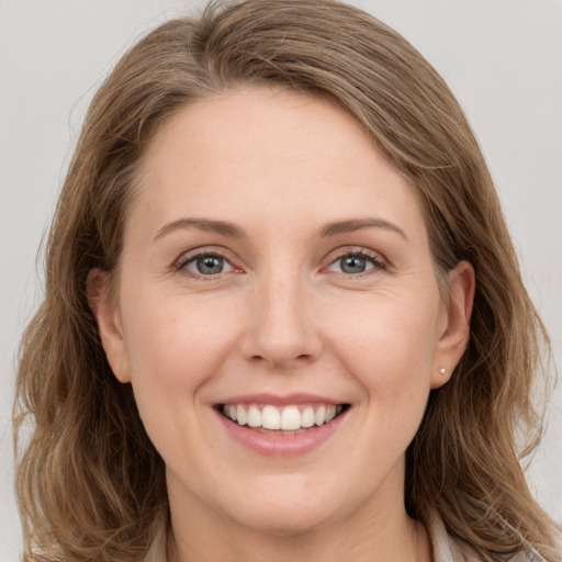 Joyful white young-adult female with long  brown hair and grey eyes