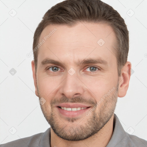 Joyful white young-adult male with short  brown hair and grey eyes