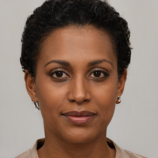 Joyful black young-adult female with short  brown hair and brown eyes