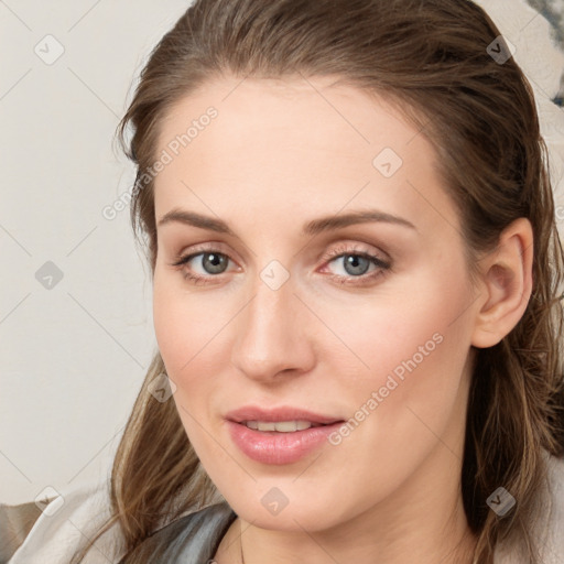 Joyful white young-adult female with medium  brown hair and blue eyes