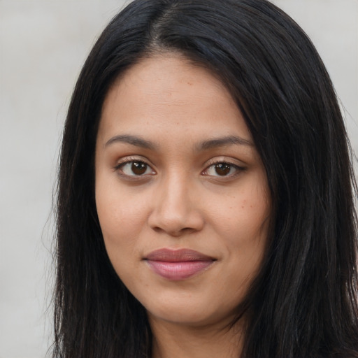 Joyful latino young-adult female with long  black hair and brown eyes