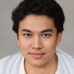 Joyful latino young-adult male with short  brown hair and brown eyes