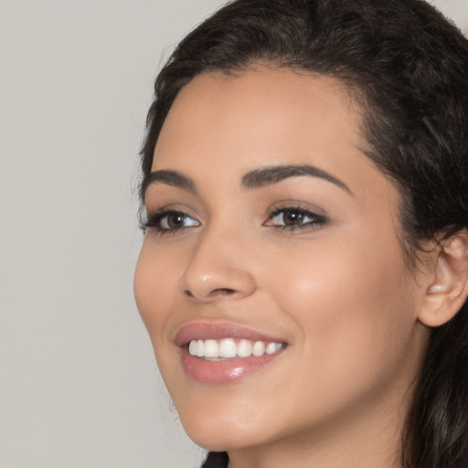 Joyful latino young-adult female with long  black hair and brown eyes