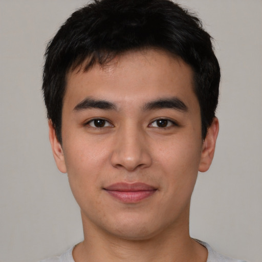 Joyful asian young-adult male with short  black hair and brown eyes