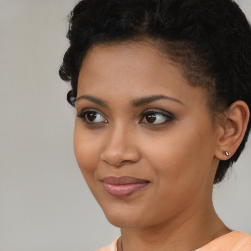 Joyful black young-adult female with short  black hair and brown eyes