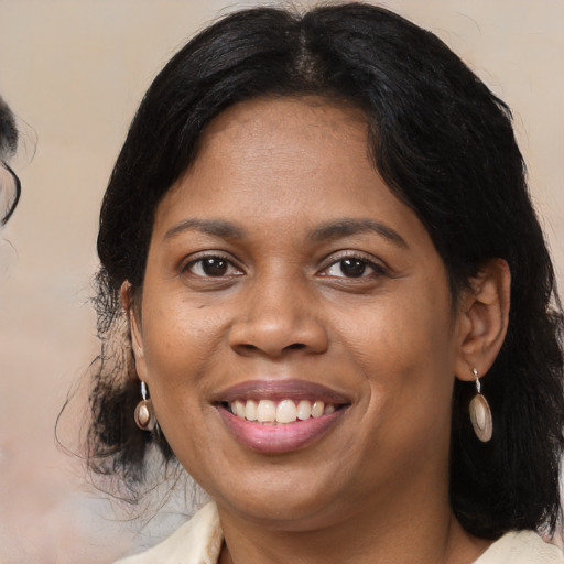 Joyful black adult female with medium  brown hair and brown eyes