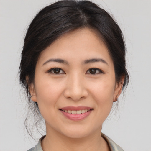 Joyful asian young-adult female with medium  brown hair and brown eyes