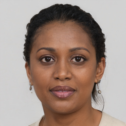 Joyful black young-adult female with short  black hair and brown eyes