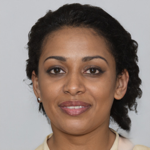 Joyful black young-adult female with short  black hair and brown eyes