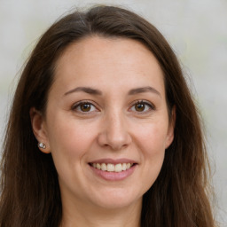 Joyful white adult female with long  brown hair and brown eyes