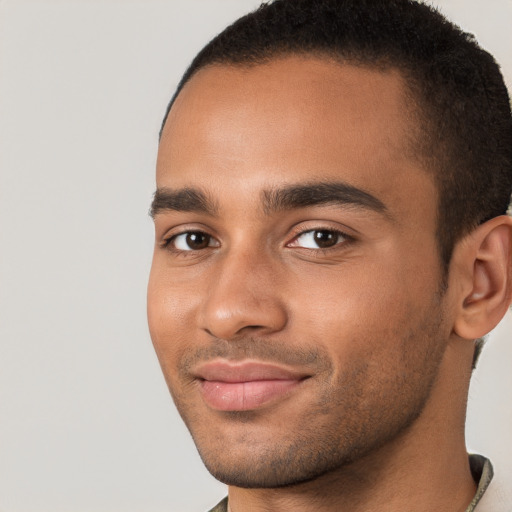 Joyful black young-adult male with short  brown hair and brown eyes