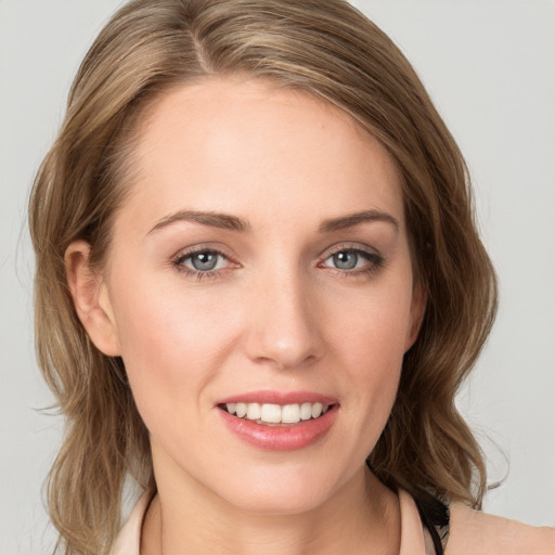 Joyful white young-adult female with medium  brown hair and blue eyes