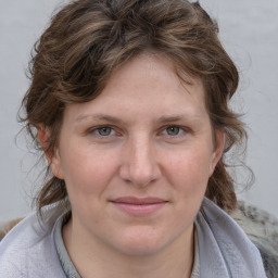 Joyful white young-adult female with medium  brown hair and blue eyes