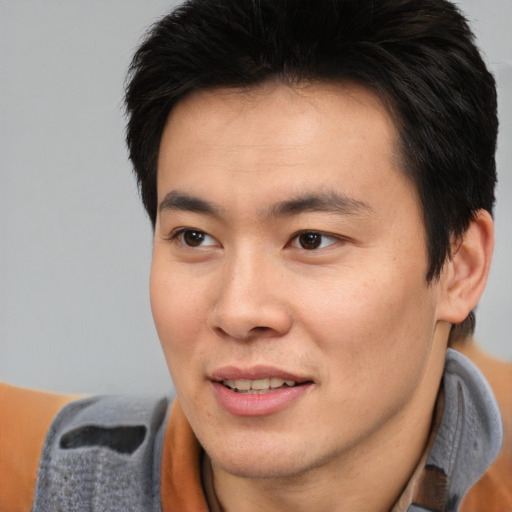 Joyful asian young-adult male with short  brown hair and brown eyes