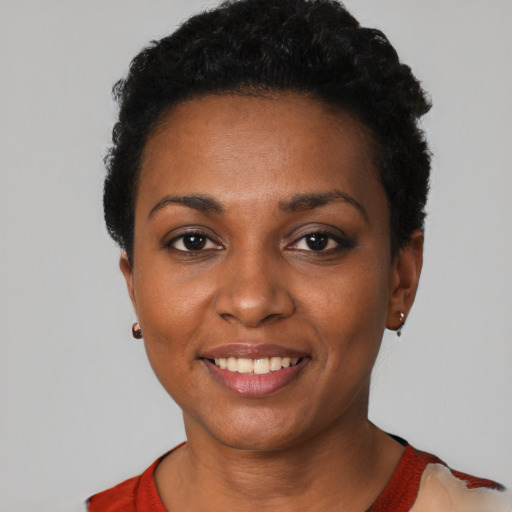 Joyful black young-adult female with short  black hair and brown eyes