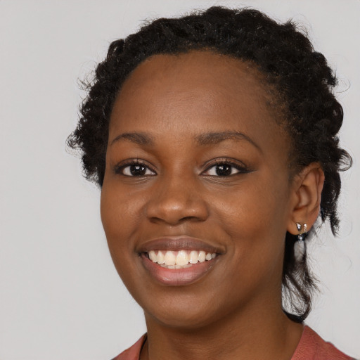 Joyful black young-adult female with long  brown hair and brown eyes