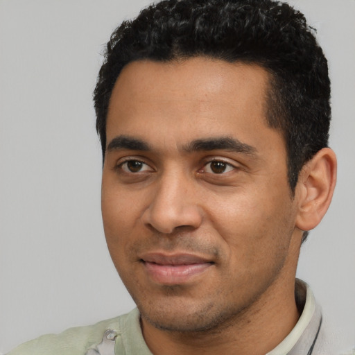 Joyful latino young-adult male with short  black hair and brown eyes
