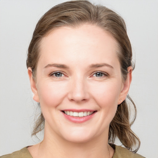 Joyful white young-adult female with medium  brown hair and grey eyes