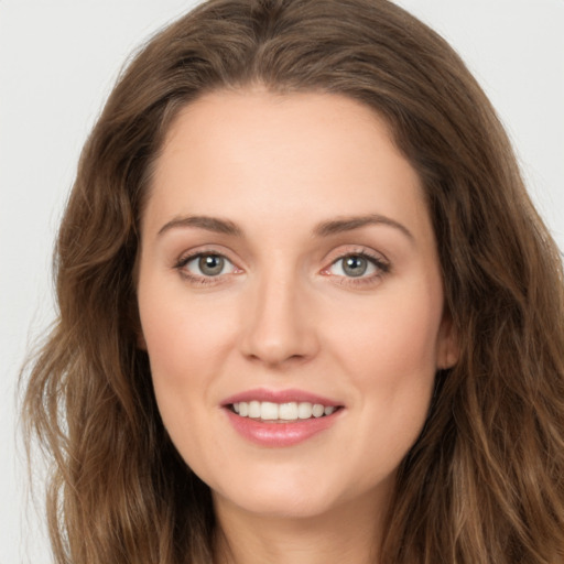 Joyful white young-adult female with long  brown hair and green eyes