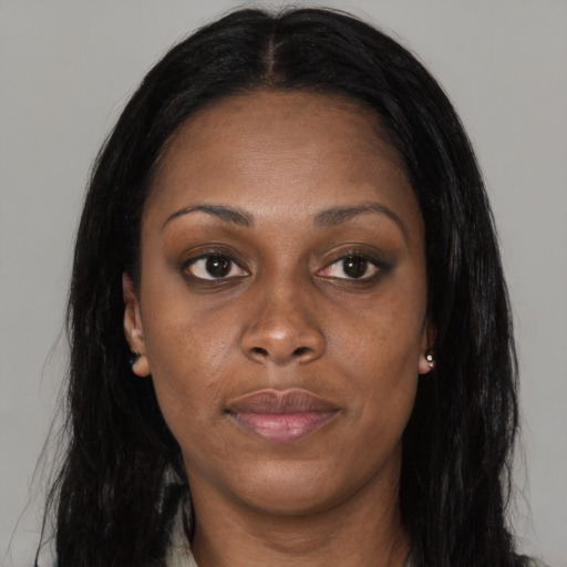 Joyful black adult female with long  brown hair and brown eyes