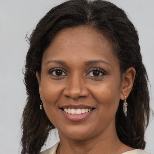 Joyful black adult female with long  brown hair and brown eyes