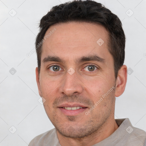 Joyful white adult male with short  brown hair and brown eyes