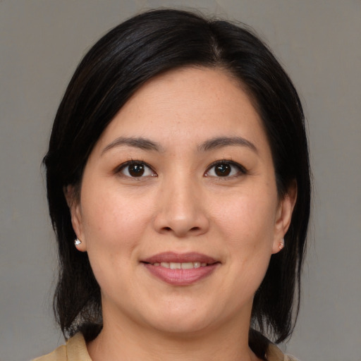 Joyful asian adult female with medium  brown hair and brown eyes