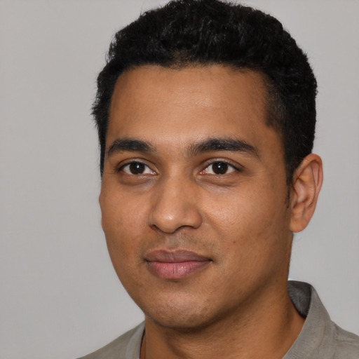 Joyful latino young-adult male with short  black hair and brown eyes