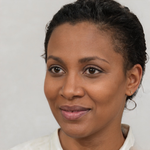 Joyful black young-adult female with short  brown hair and brown eyes