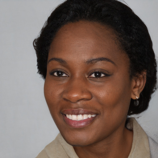 Joyful black young-adult female with short  black hair and brown eyes