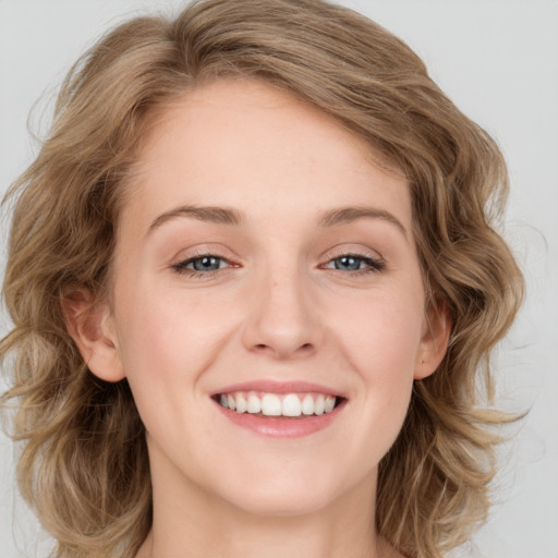 Joyful white young-adult female with medium  brown hair and blue eyes