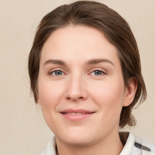 Joyful white young-adult female with medium  brown hair and green eyes