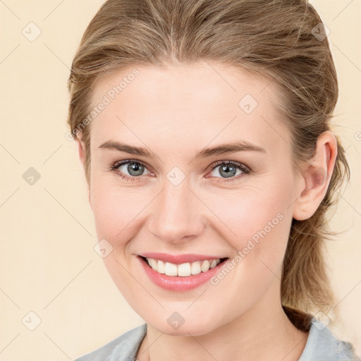 Joyful white young-adult female with medium  brown hair and blue eyes