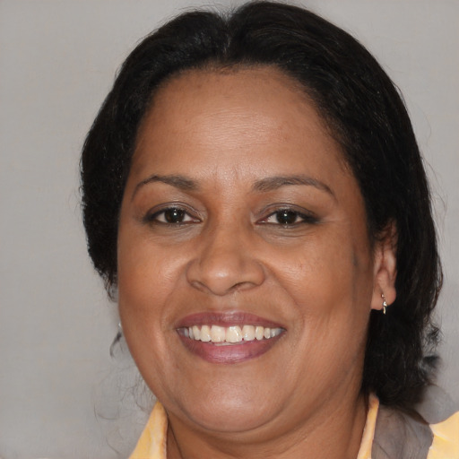 Joyful black adult female with medium  brown hair and brown eyes