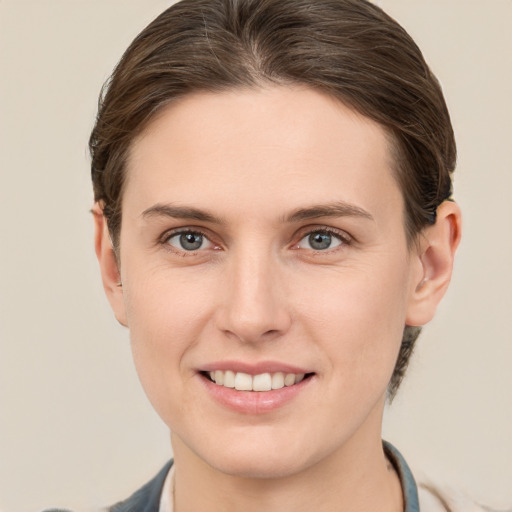 Joyful white young-adult female with short  brown hair and grey eyes