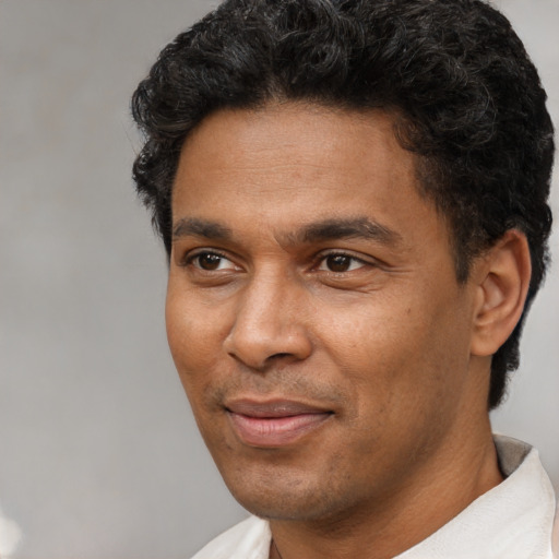 Joyful white adult male with short  black hair and brown eyes