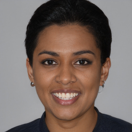 Joyful black young-adult female with short  black hair and brown eyes