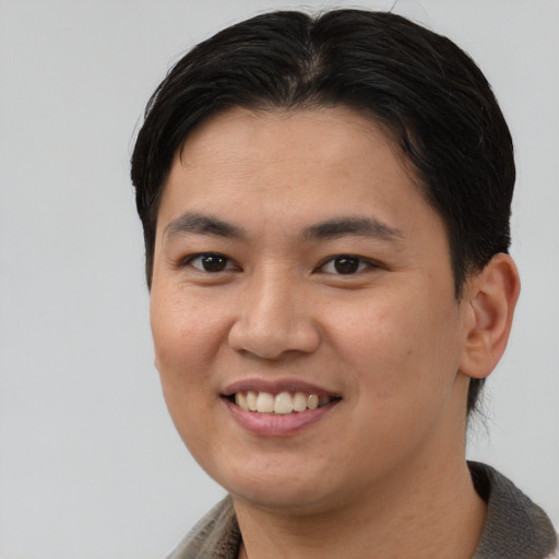Joyful asian young-adult female with short  brown hair and brown eyes