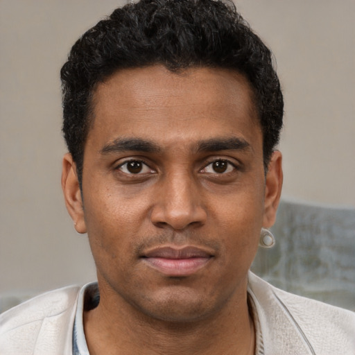 Joyful black young-adult male with short  black hair and brown eyes