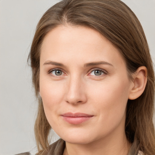 Joyful white young-adult female with long  brown hair and grey eyes