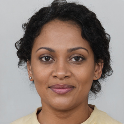 Joyful black young-adult female with short  brown hair and brown eyes
