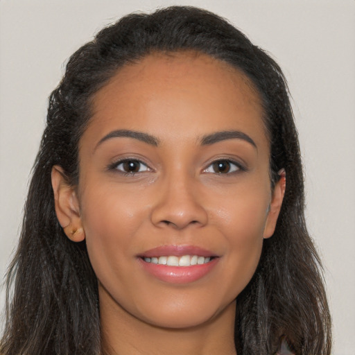 Joyful latino young-adult female with long  brown hair and brown eyes