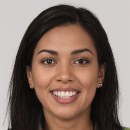 Joyful latino young-adult female with long  brown hair and brown eyes