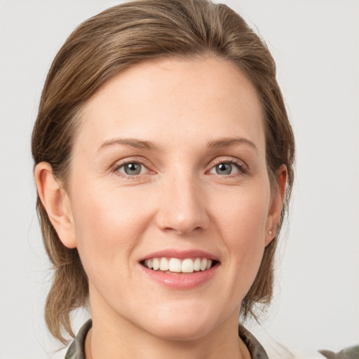 Joyful white young-adult female with medium  brown hair and grey eyes