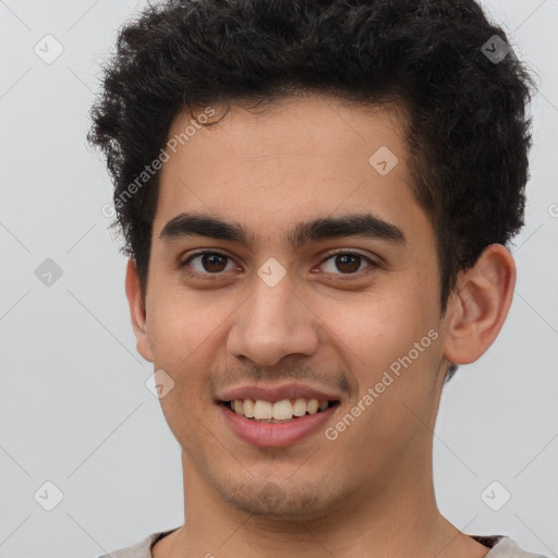 Joyful latino young-adult male with short  brown hair and brown eyes